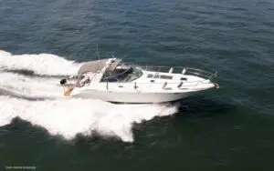1999 Sea Ray 400 Sundancer sports cruiser underway with bimini up, sold by Davis Marine Brokerage