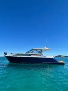 Chris-Craft Roamer 43 Heritage bow-quarter view at anchor on clear turquoise water