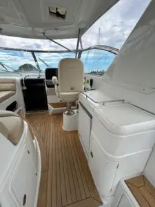Helm deck of the Chris-Craft Roamer 43 under the hardtop with helm seat and teak sole