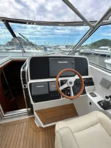 Helm station of the Chris-Craft Roamer 43 with Raymarine displays and timber wheel