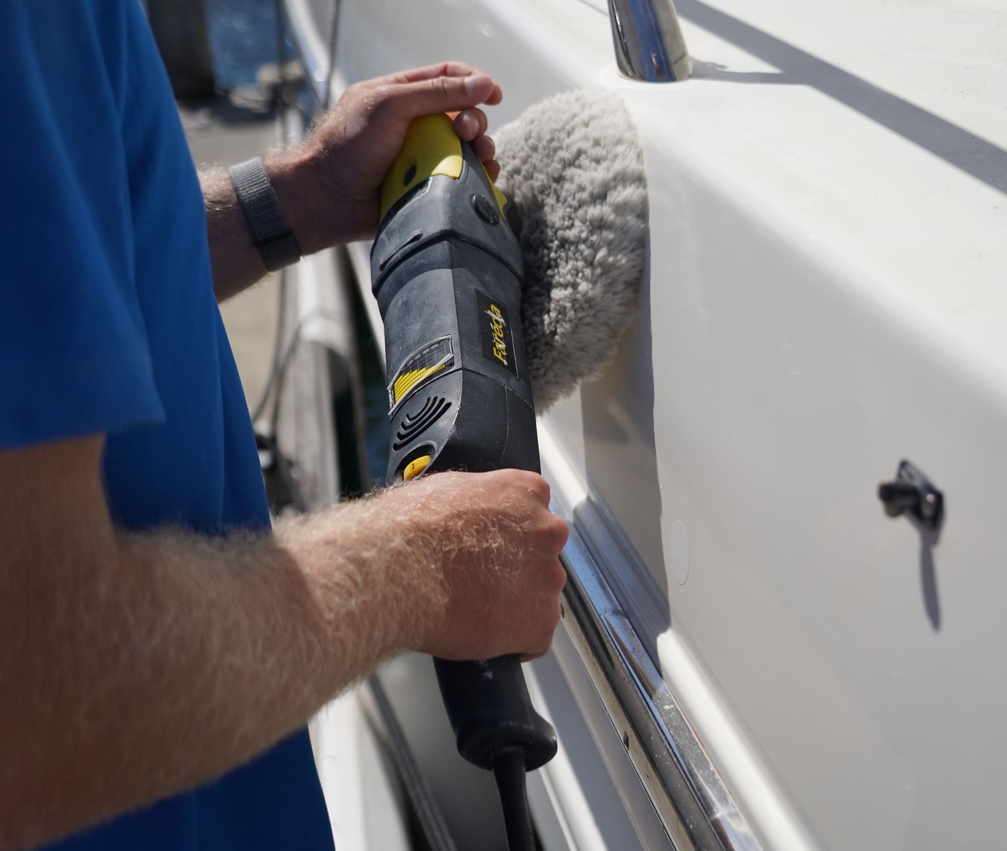 Machine polishing a boat hull side to restore gloss after cutting