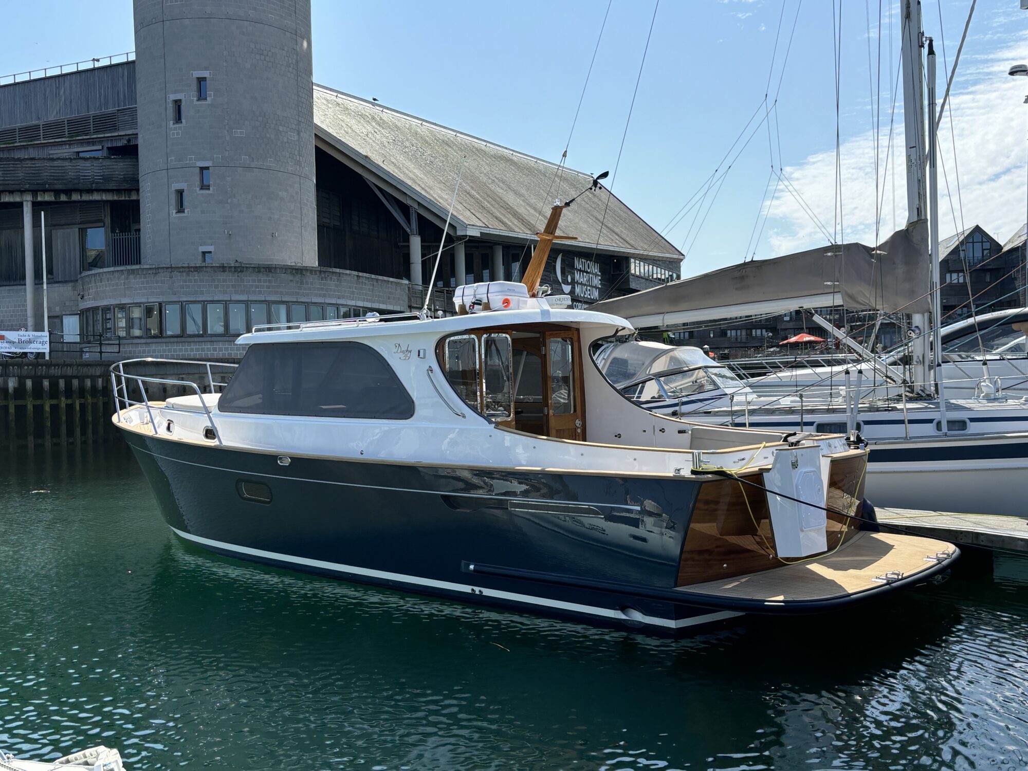 Duchy 35 Laila moored alongside a pontoon showing her grey hull and teak trim
