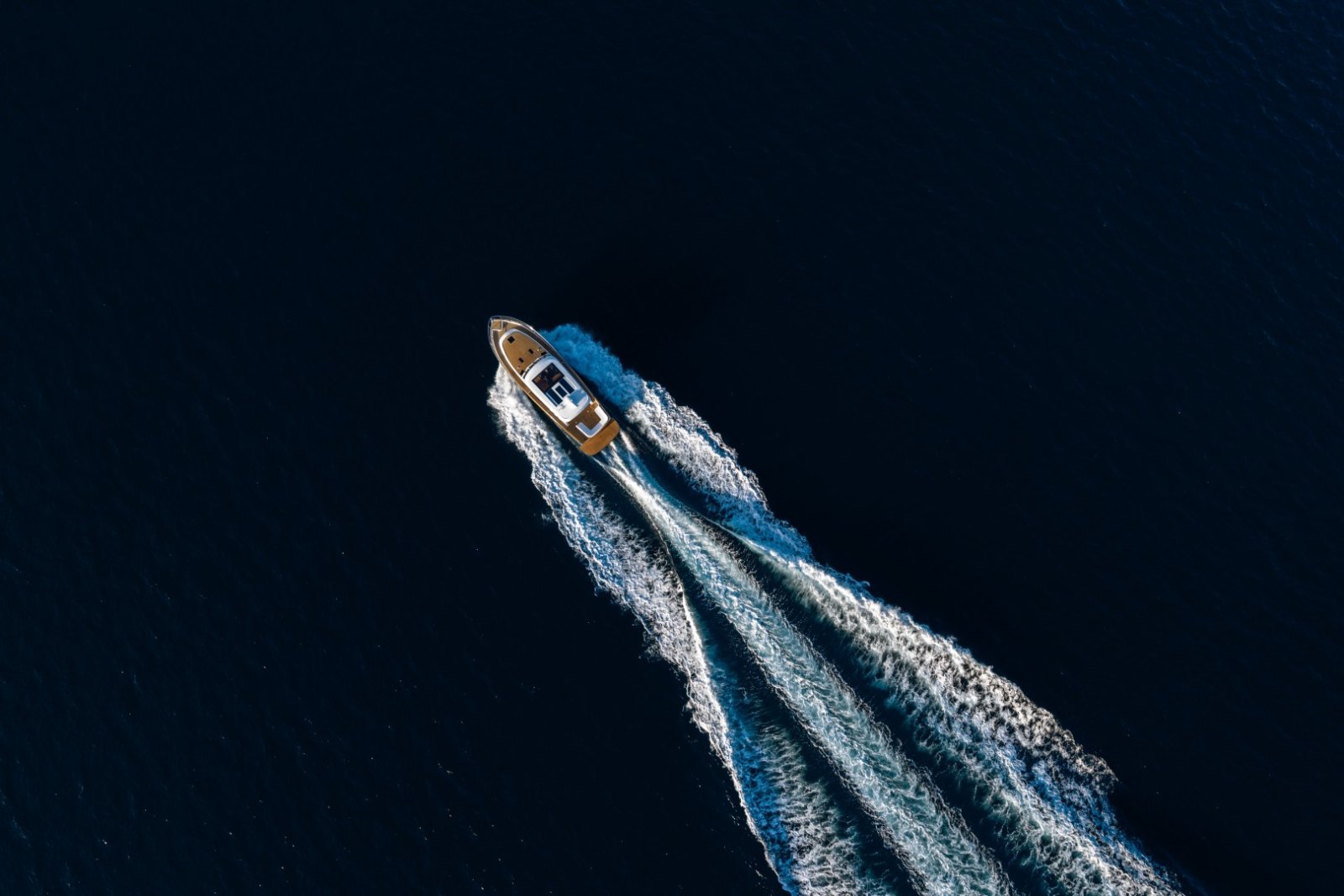 Aerial view of the Cockwells Duchy 45 motor launch under way at dusk, leaving a long wake