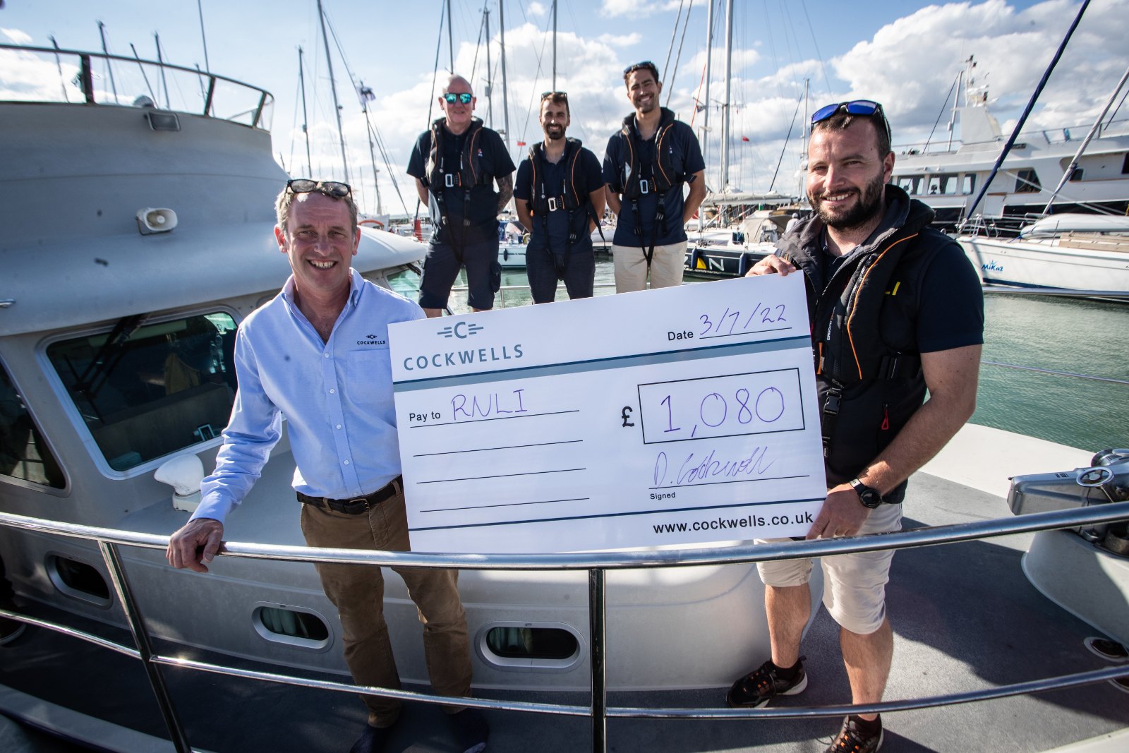 Presentation of a cheque to the RNLI at Yarmouth Harbour during the Cockwells Owners' Rally 2022