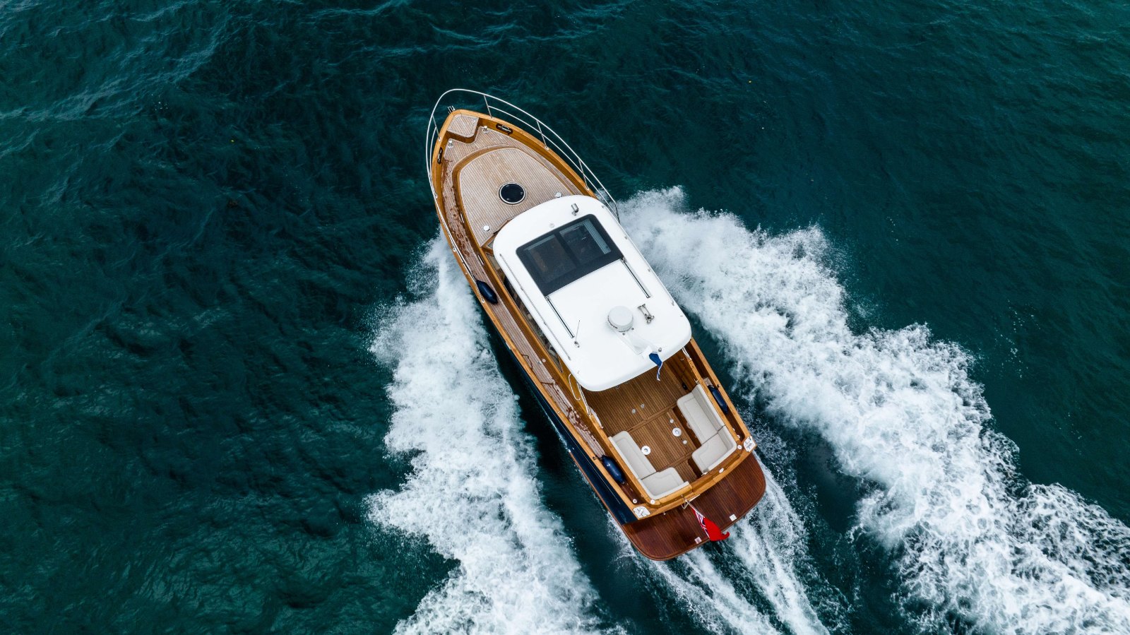 Duchy 35 seen directly from above at speed, showing teak decks, white hardtop and cockpit seating