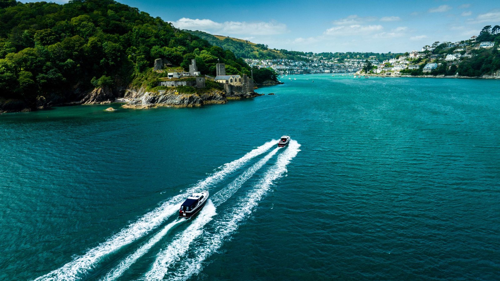 A boat from the Cockwells rally fleet entering the River Dart below Dartmouth Castle, seen from above