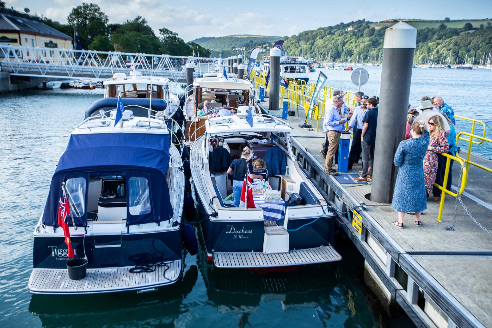 Two Duchy 27s, 'Tigger' and 'Duchess', rafted at Dartmouth Town Jetty with rally guests on the pontoon