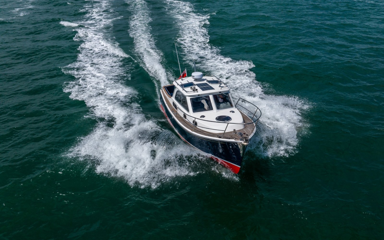 Duchy 35 with a dark hull seen from the drone, turning at speed on the Solent during the 2024 Cockwells Owners' Rally